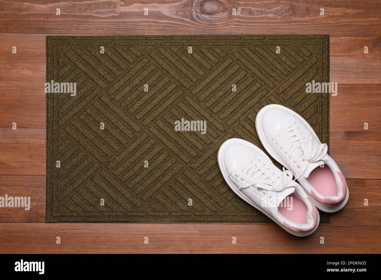 New clean door mat with shoes on wooden floor, flat lay Stock Photo Alamy