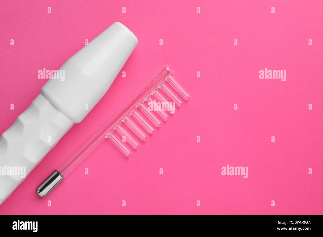 Modern darsonval with nozzle on pink background, flat lay. Space for ...