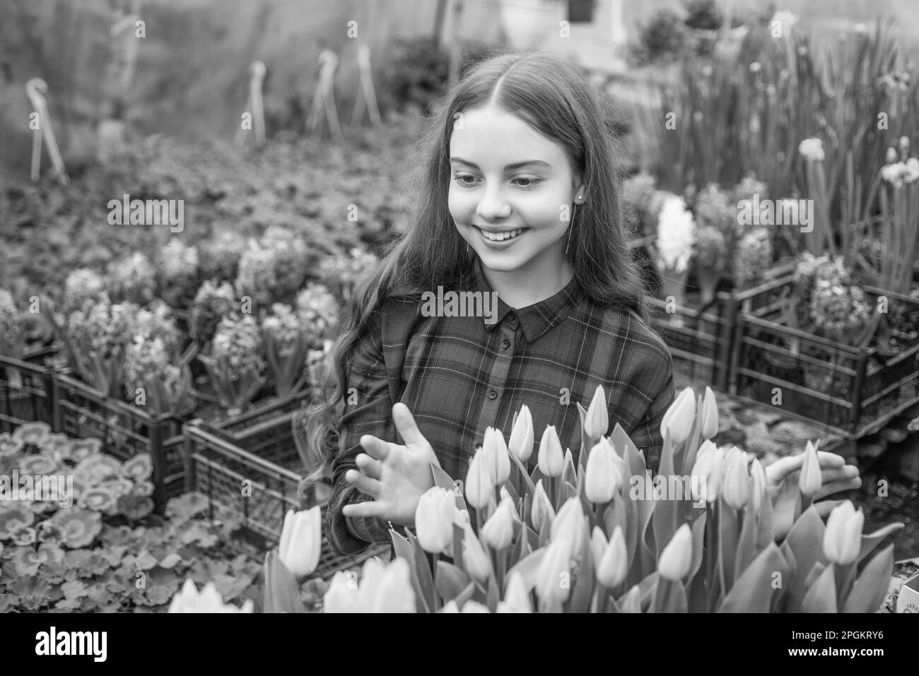 happy teen girl florist planting pot plants in greenhouse, gardener Stock Photo