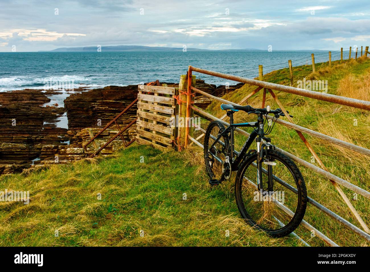 Island of Hoy, Orkney, over the Pentland Firth, from a field gate near the village of Mey, Caithness, Scotland, UK.  A mountain bike in the foreground Stock Photo