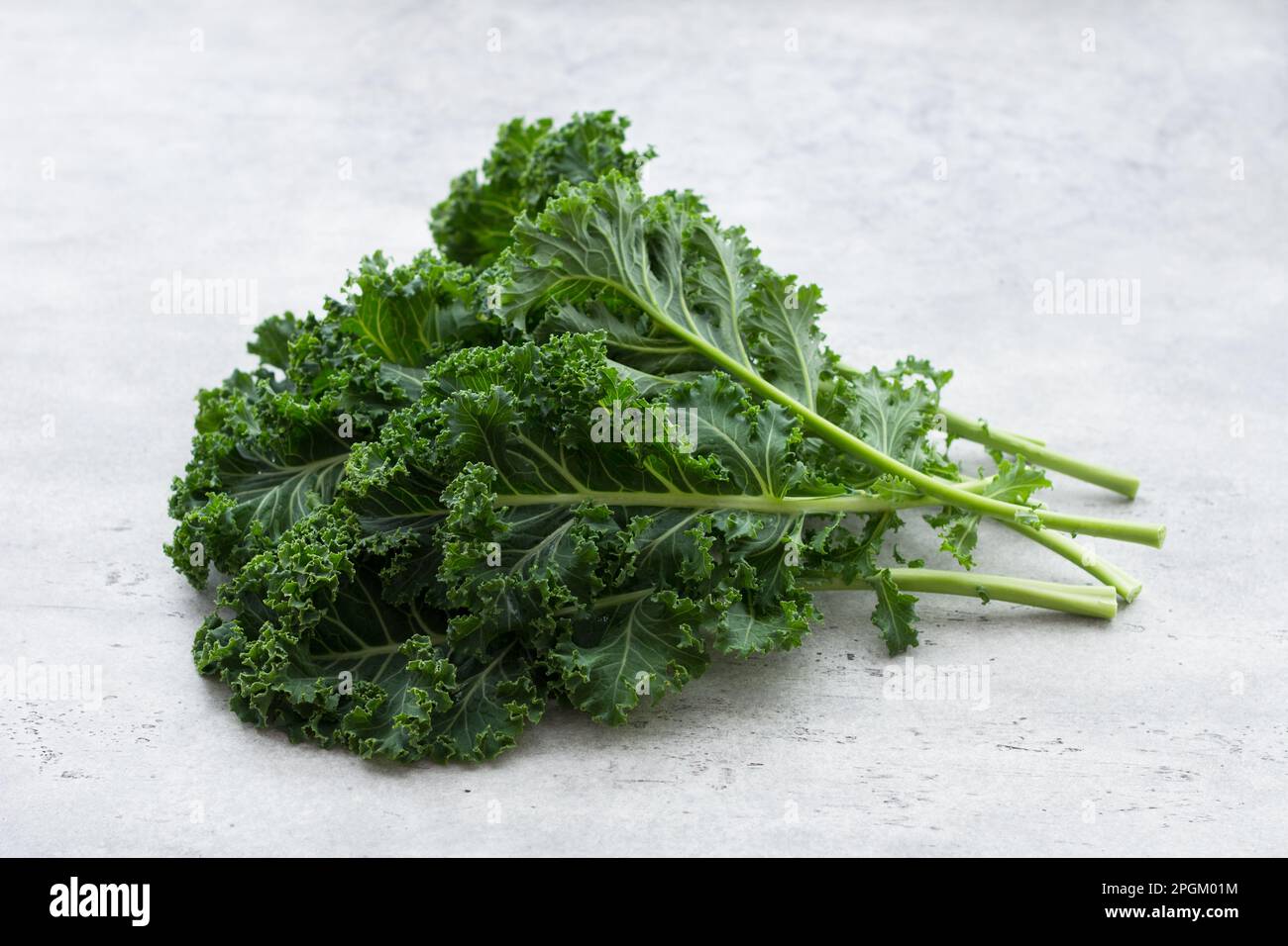 Fresh green curly kale leaves on a light gray background. Superfood, diet food, healthy food Stock Photo