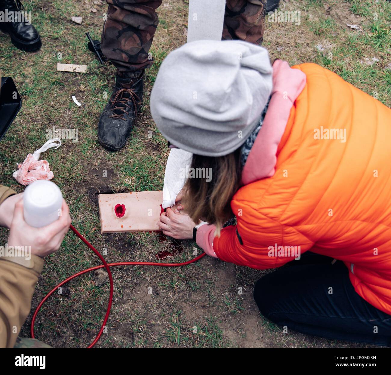 Woman trains to stop bleeding from a gunshot wound using tamponade on a bullet wound simulator