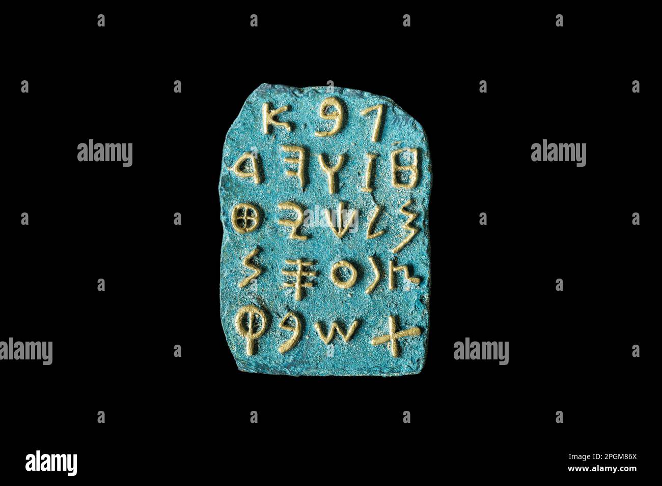 Reproduction of Phoenician alphabet with gilded letters on a stone