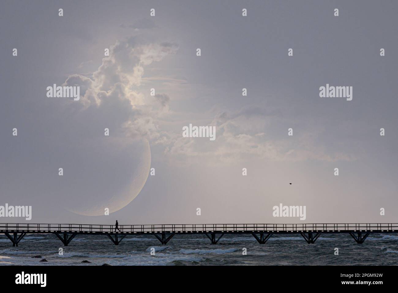The way, moon in the picture, a person on the bridge. Der Weg, Mond im Bild, ein Mensch auf der Brücke, Meer und Wellen Stock Photo