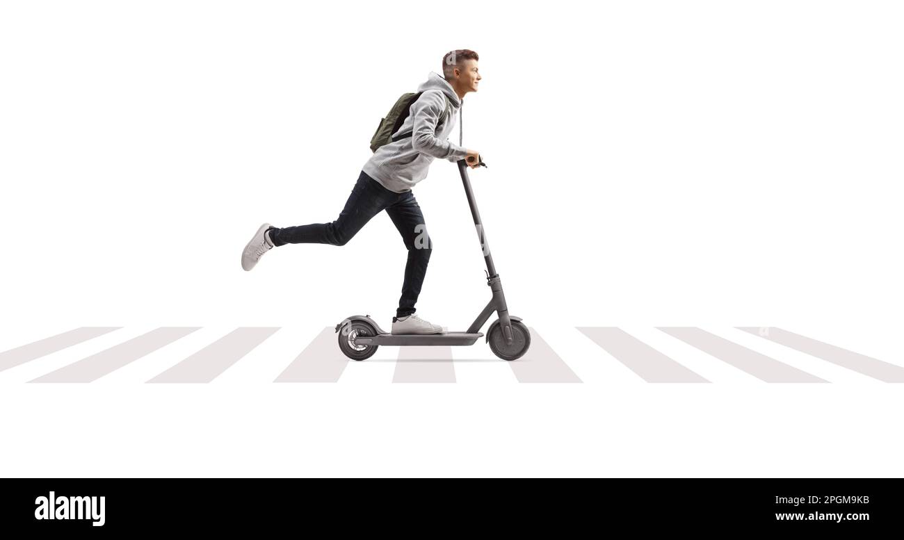 Full length shot of a male student with a backpack riding an electric scooter at pedestrian zebra crossing isolated on white background Stock Photo