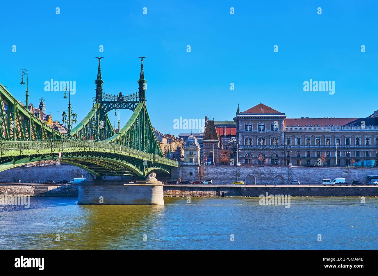 Historic green Art Nouveau Liberty Bridge across Danube River with a view on the Corvin University on the opposite bank, Budapest, Hungary Stock Photo