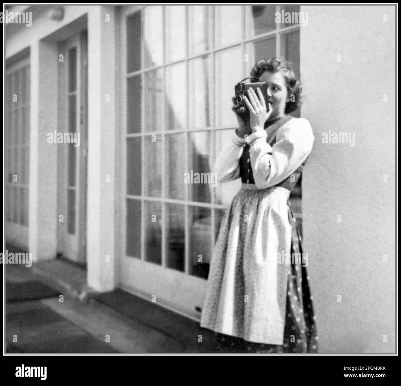 Eva Braun, mistress (later wife) of Adolf Hitler, standing on terrace in typical Bavarian dress, taking a photograph with her box camera, at The Berghof, Berchtesgaden, Bavaria Nazi Germany, 1930s, wife, & past mistress of Adolf Hitler - From The Eva Braun Photo Albums Stock Photo