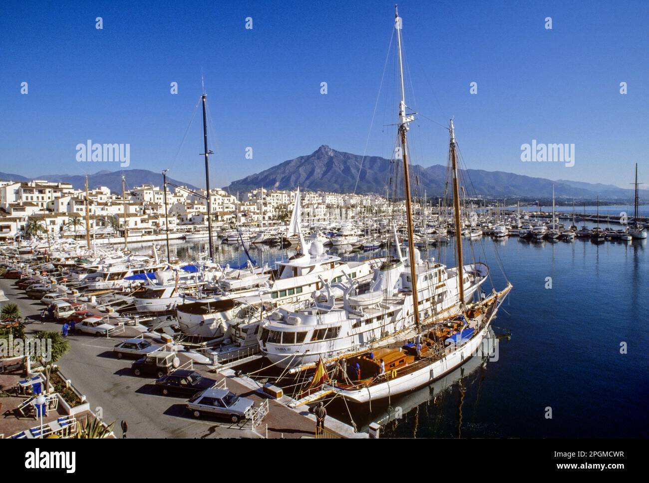 PUERTO BANUS Vintage 1980s historic retro overview of harbour at Puerto Banus Marbella with luxury yachts in foreground Costa del Sol Southern Spain Marbella Vintage Retro 1980s Puerto Bank us Marbella Spain with rare landscape view over the styles fashions and luxury sailing motor yachts moored in Puerto Banus Marina Port of the 80s era. Marbella Andalucia Spain Stock Photo