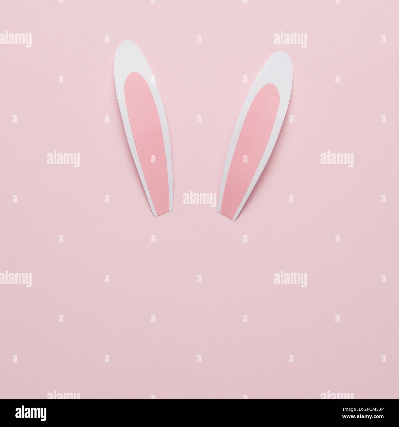 Rabbit or bunny paper ears on pink background. Minimal Easter concept. Stock Photo