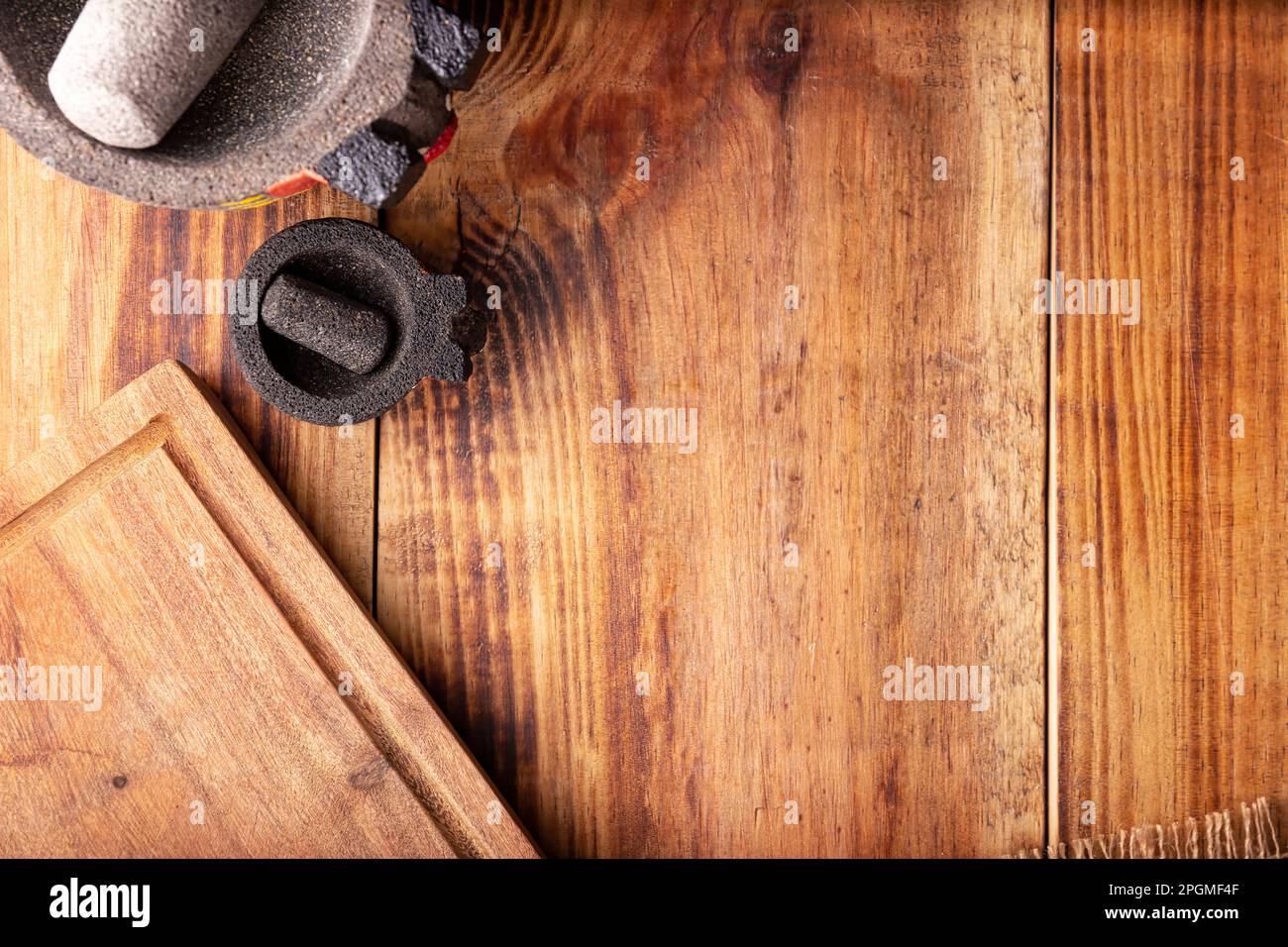 Rustic kitchen concept background. Stone molcajetes and cutting board on rustic wooden table. Table top view. Stock Photo