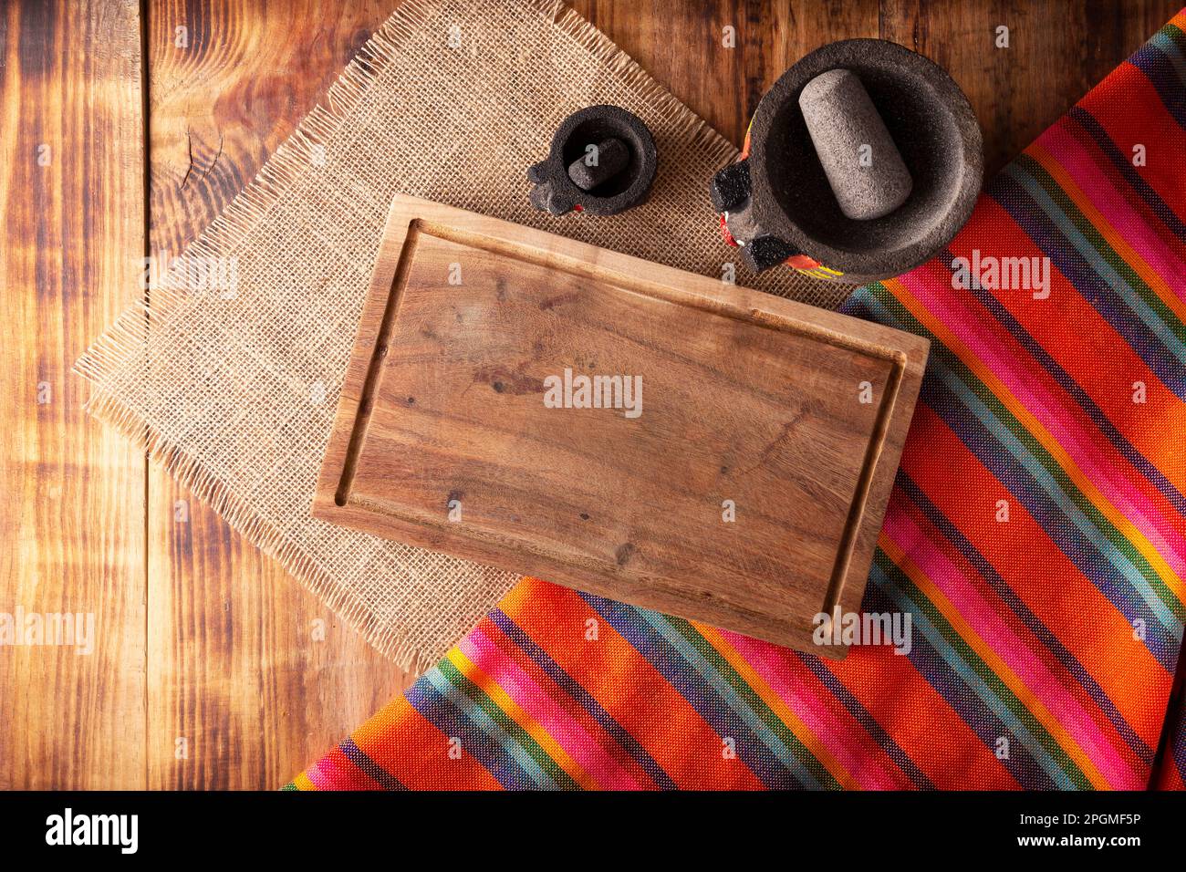 Rustic kitchen concept background. Stone molcajetes and cutting board on rustic wooden table. Table top view. Stock Photo