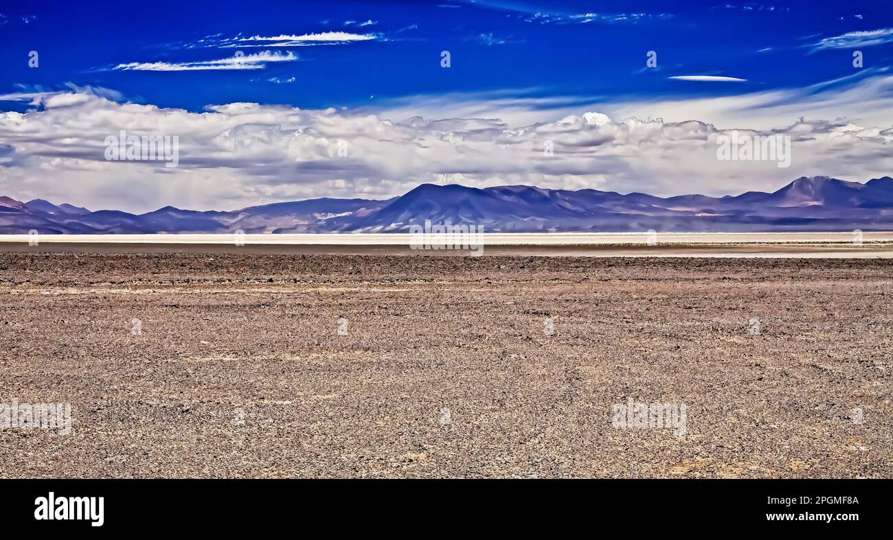 Flat endless arid life hostile plain of dried salt lake with blurred mountain range at heat flicker, spectacular cloudy sky - Maricunga,  Atacama dese Stock Photo