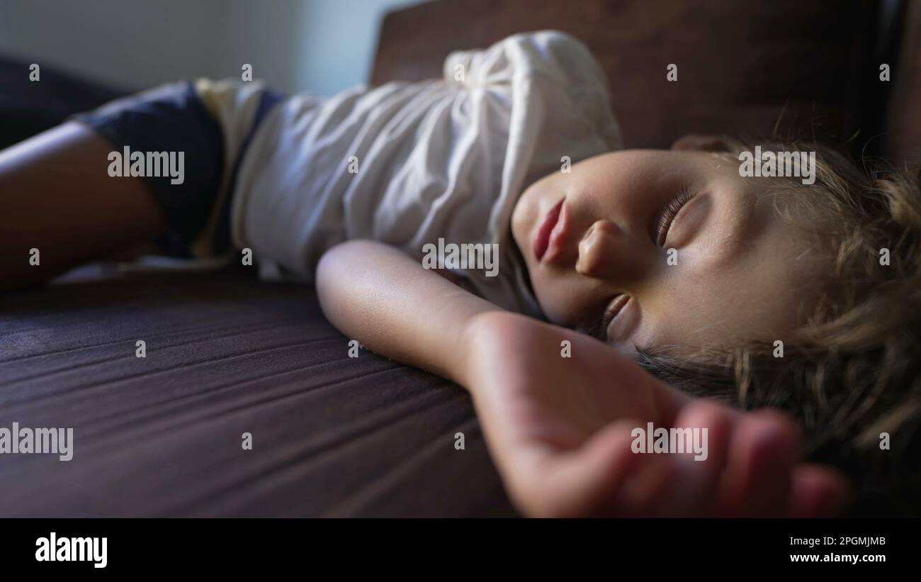 One child asleep during afternoon nap on couch. adorable little boy