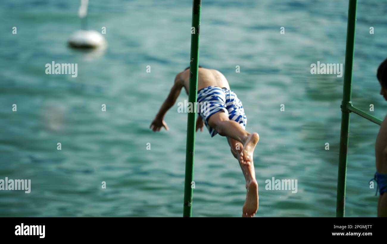 One young boy diving into lake water enjoying summer vacations. Child ...