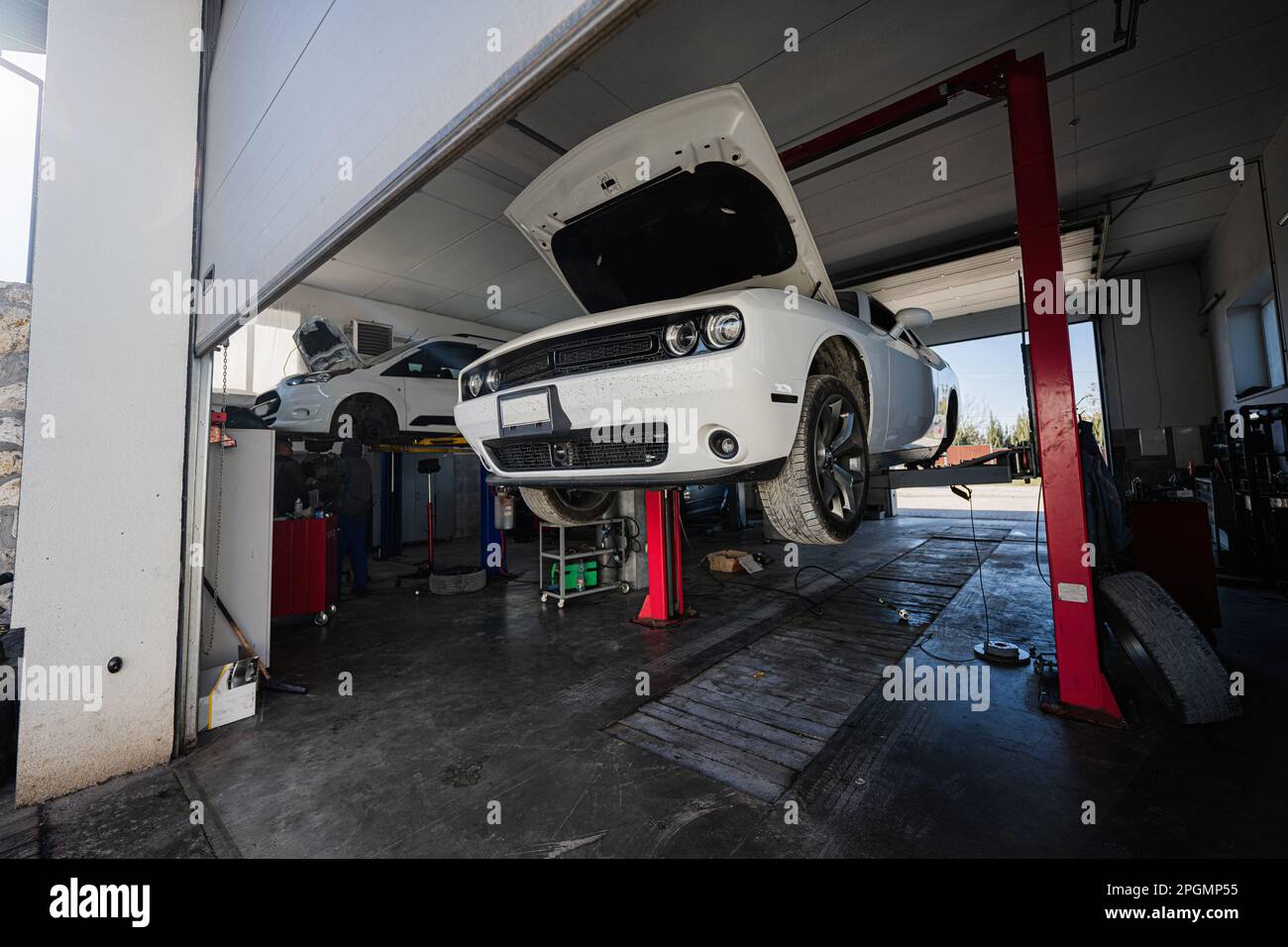 Muscle car with open hood at service repair station in lift Stock Photo ...
