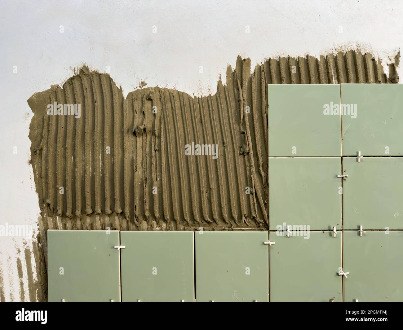 Construction background. Tile adhesive is applied to the wall for