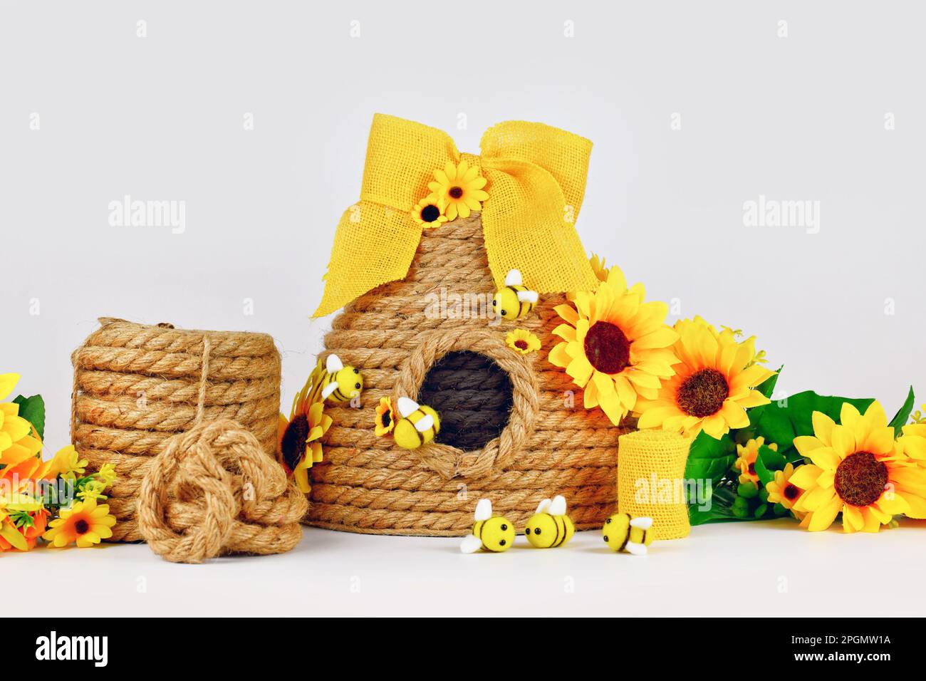 https://c8.alamy.com/comp/2PGMW1A/diy-rope-beehive-decoration-with-materials-like-fake-flowers-jute-rope-and-felt-bees-2PGMW1A.jpg