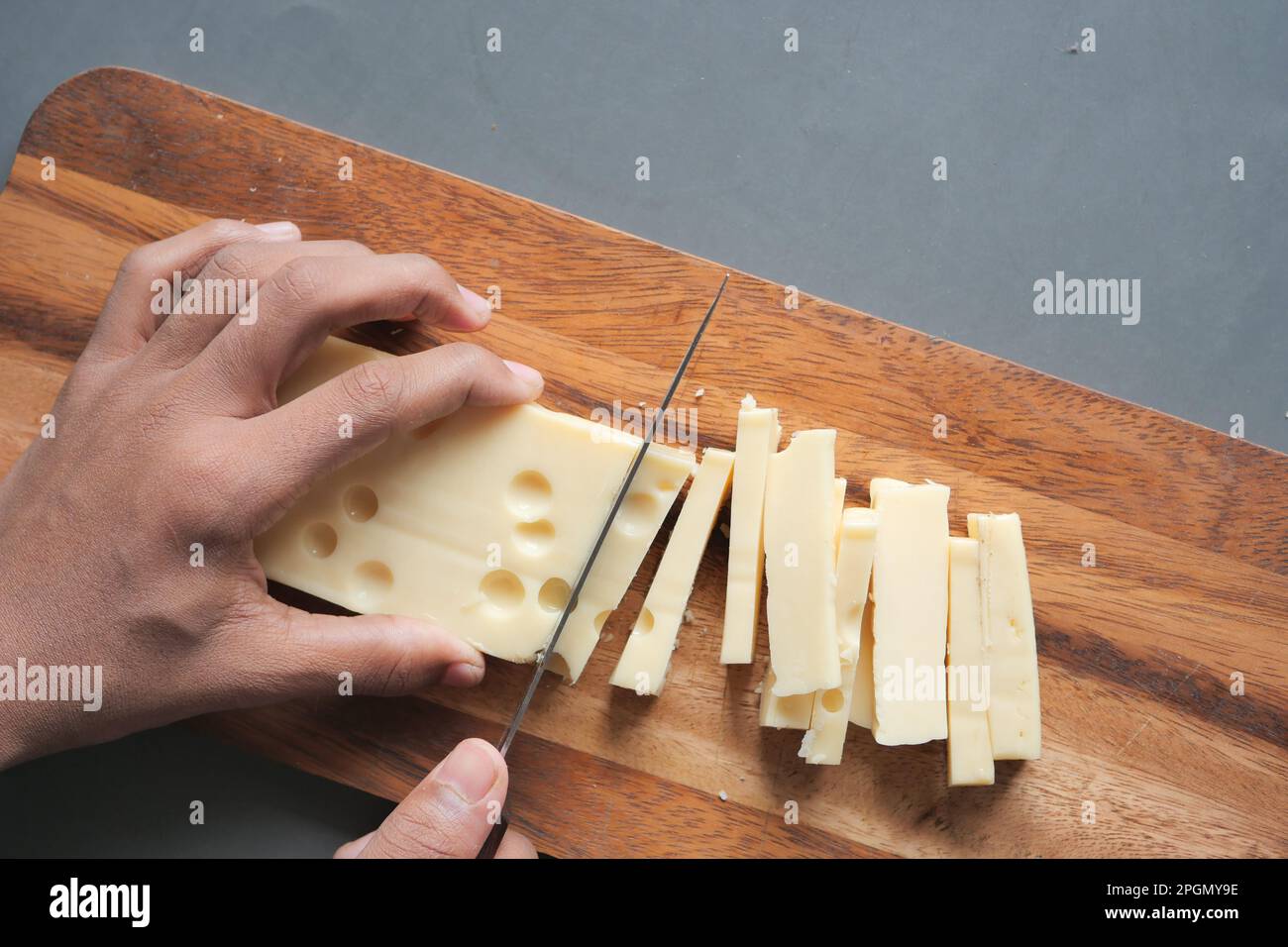 cutting cheese with knife on a chipping board Stock Photo Alamy