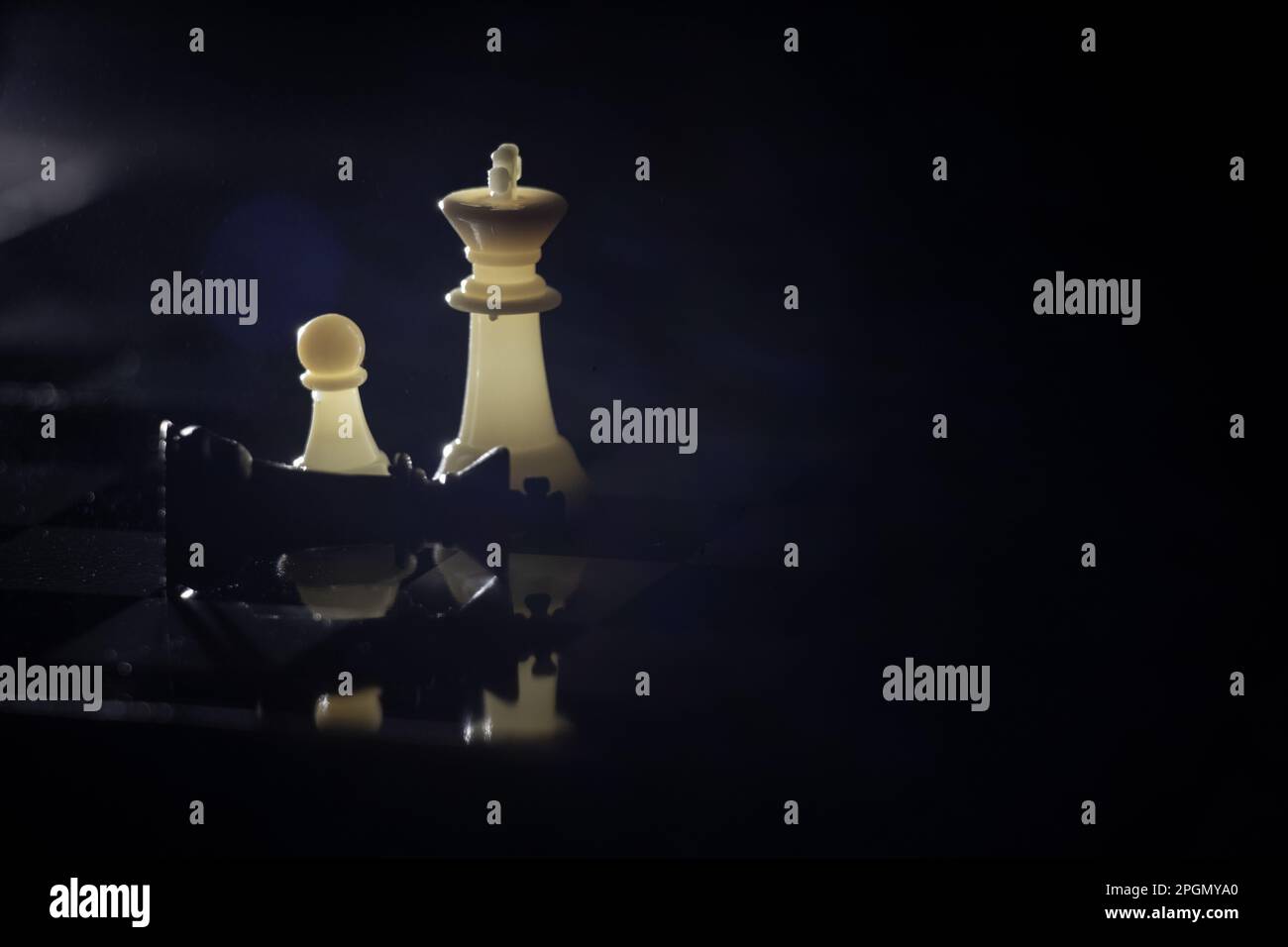 chess pieces on a chessboard in a dark room illuminated by a lantern ...