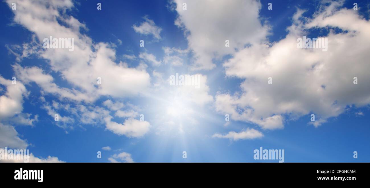 Couds in the blue sky. Bright midday sun illuminates the space . Wide ...