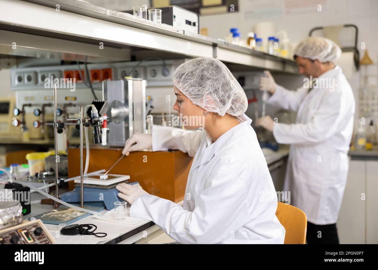 Female laboratory assistant weighs tablets on precision scales in ...
