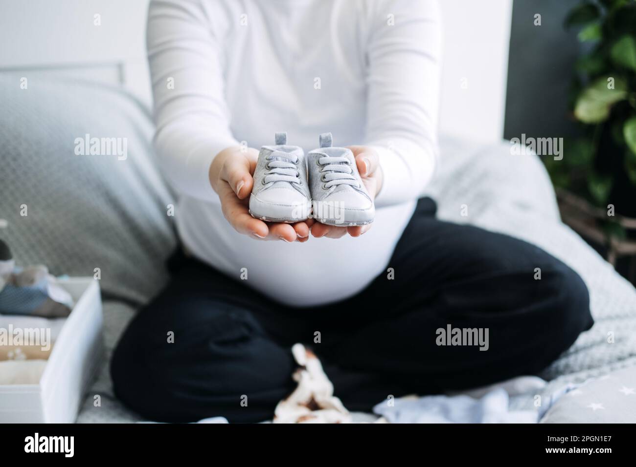 How to Organize Newborn Baby Clothes. Pregnant woman Using ornament