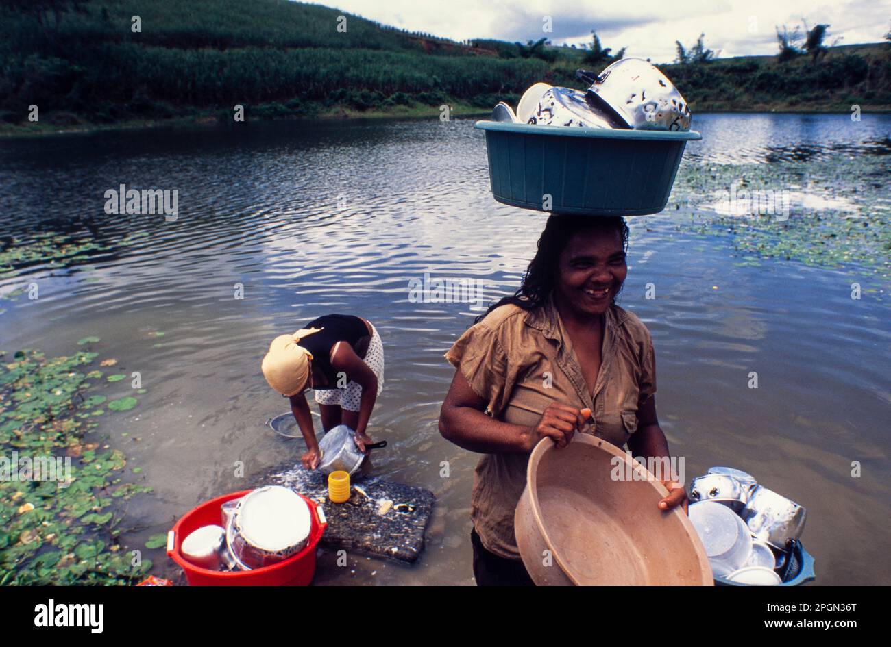 Daily life in countryside Northeastern Brazil, Black women wash the dishes in the river, toothless woman smiles joyfully, Palmares, Pernambuco State. Stock Photo