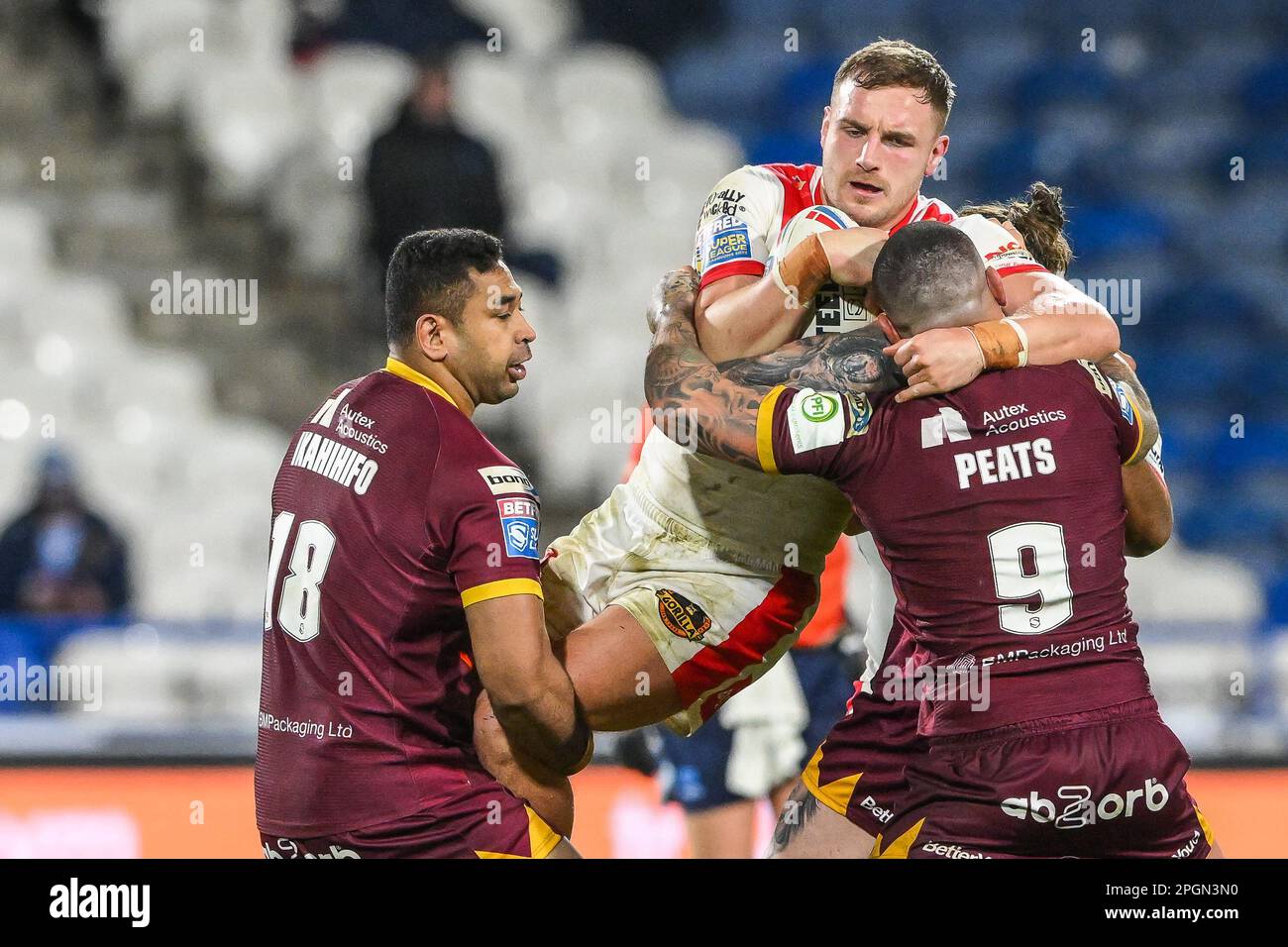 Matty Lees #10 of St Helens is tackled by Nathan Peats #9 and Seb Ikahihifo #18 of Huddersfield Giants during the Betfred Super League Round 6 match Huddersfield Giants vs St Helens at John Smith's Stadium, Huddersfield, United Kingdom, 23rd March 2023  (Photo by Craig Thomas/News Images) Stock Photo