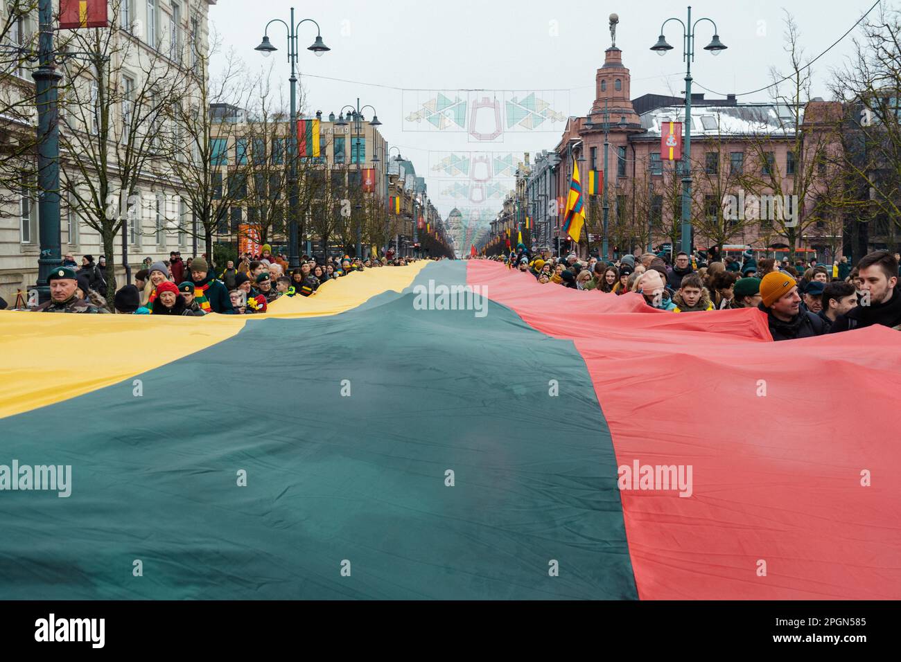 Vilnius  Lithuania - March 11 2022:  Huge Lithuanian flag along Gedimino avenue in Vilnius, carried by people with Lithuanian and Ukrainian flags Stock Photo