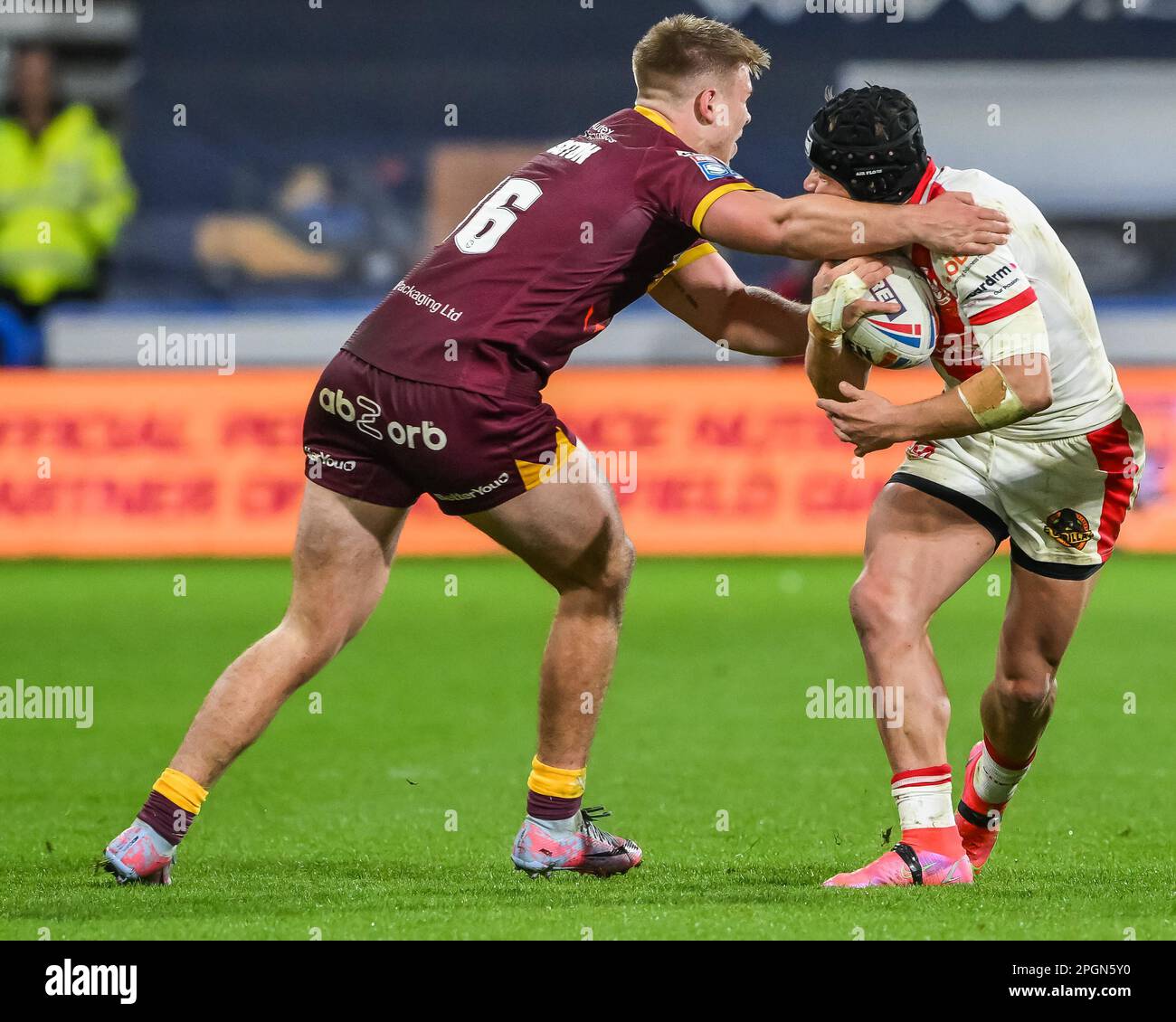 Jonny Lomax #6 of St Helens receives a hi tackle from Harry Rushton #16 of Huddersfield Giants during the Betfred Super League Round 6 match Huddersfield Giants vs St Helens at John Smith's Stadium, Huddersfield, United Kingdom, 23rd March 2023  (Photo by Craig Thomas/News Images) Stock Photo