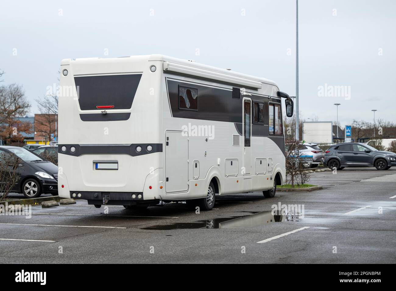 One motorhome takes up five parking spaces for cars in one parking space Stock Photo