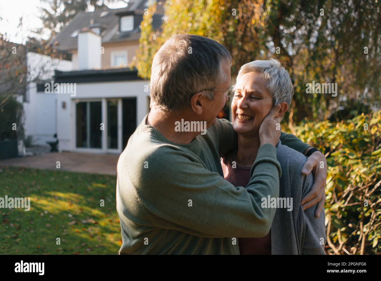 Happy affectionate senior couple hugging in garden Stock Photo