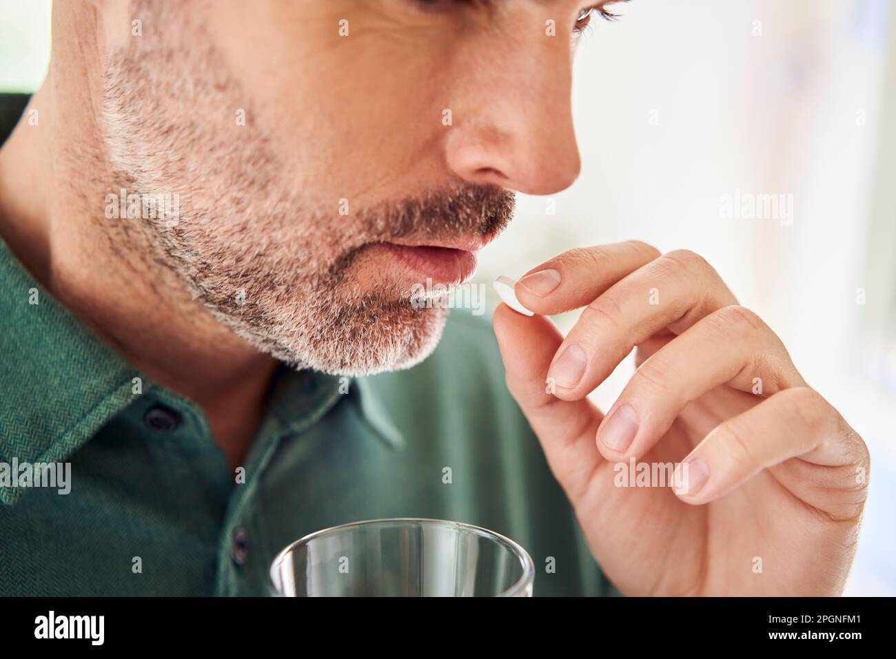 Close-up of adult man taking pill Stock Photo