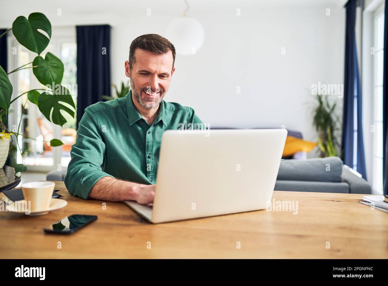 Mature businessman working from home using laptop Stock Photo