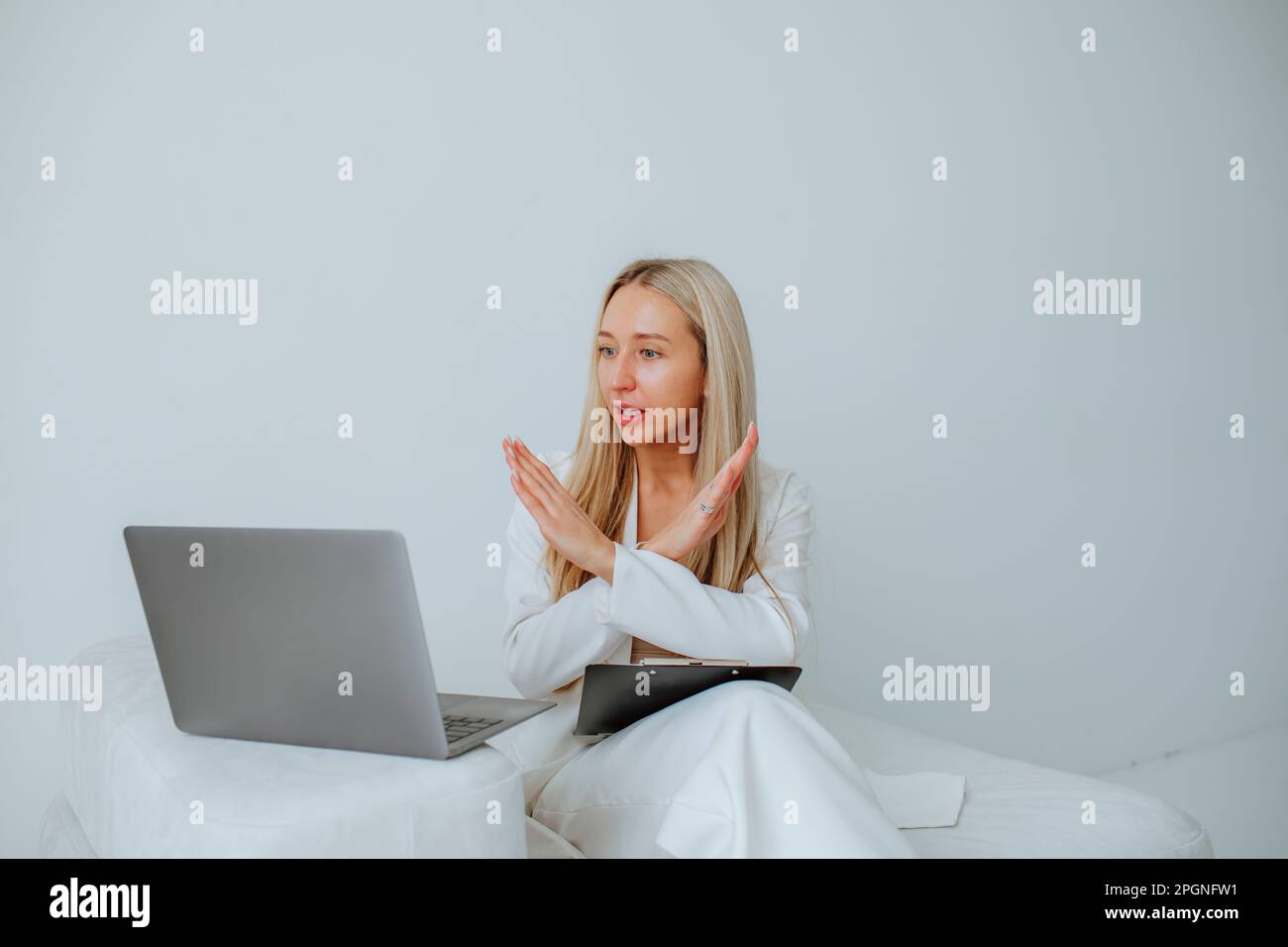Young psychologist gesturing on video through laptop at clinic Stock Photo