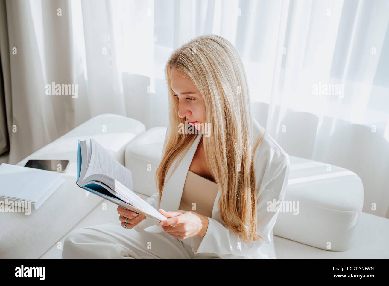 Young psychologist reading book in clinic Stock Photo