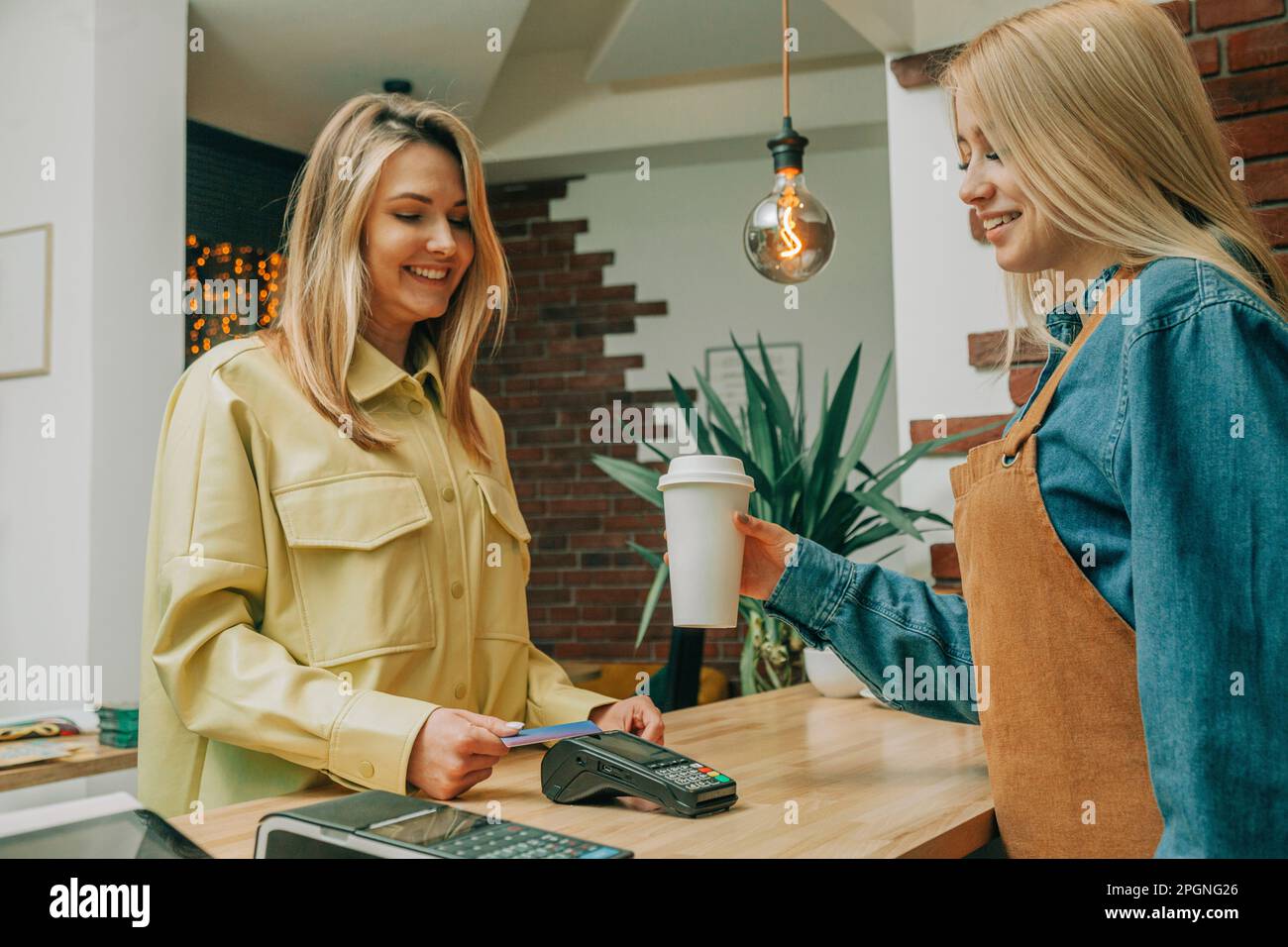 Smiling customer paying via tap to pay at coffee shop Stock Photo Alamy