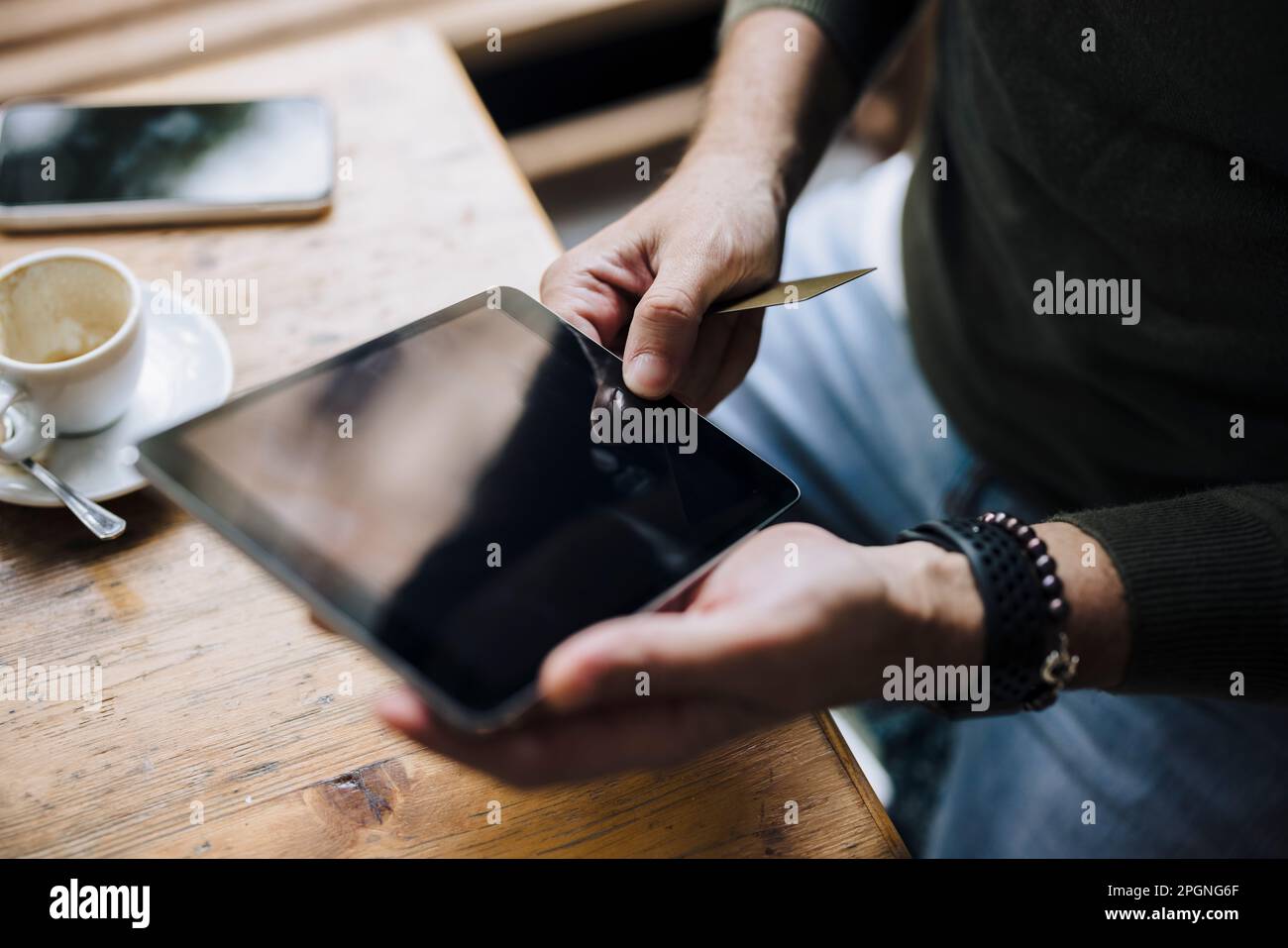 Hands of man using tablet PC on table in cafe Stock Photo