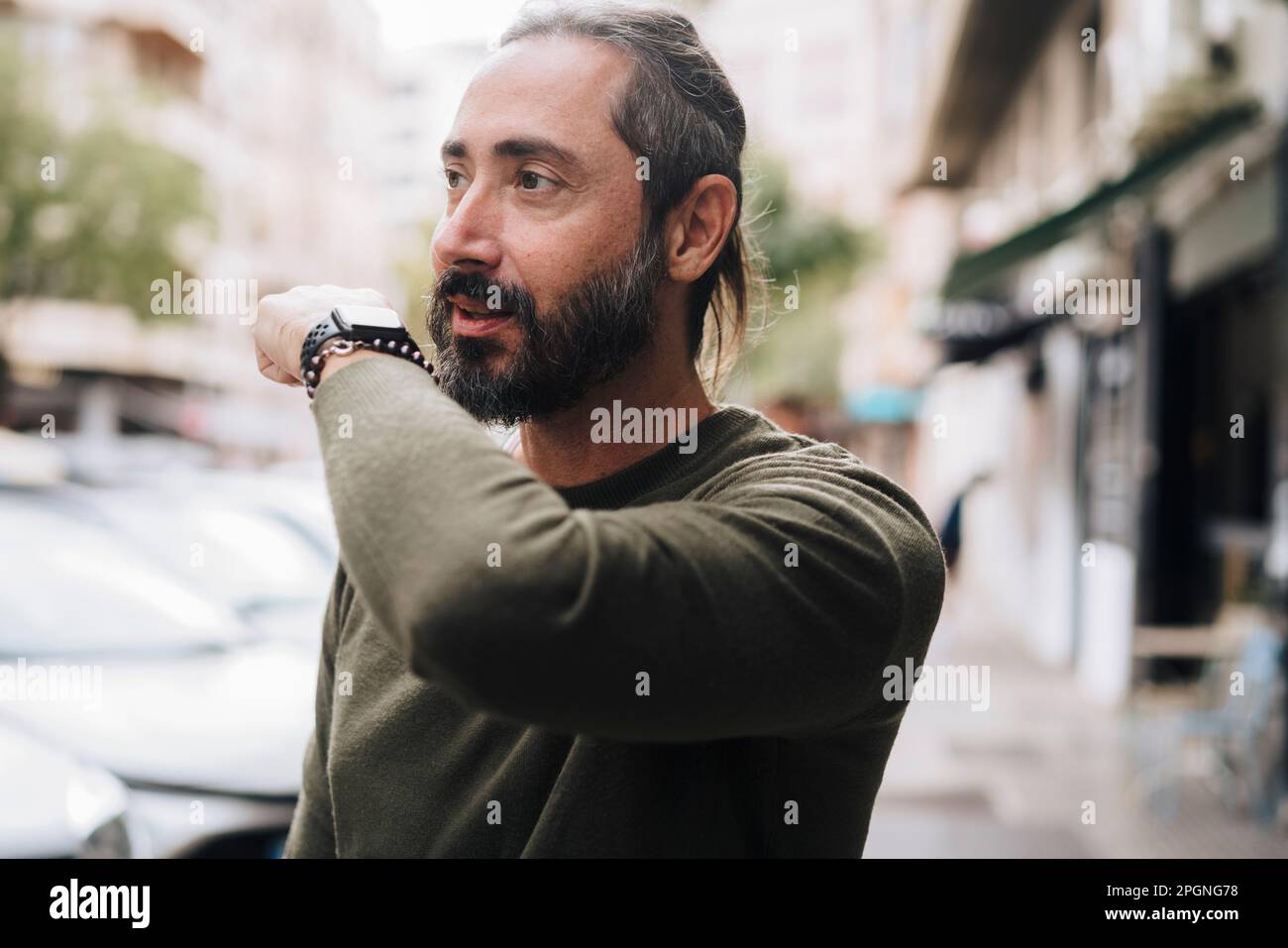 Mature man with beard talking into smart watch Stock Photo