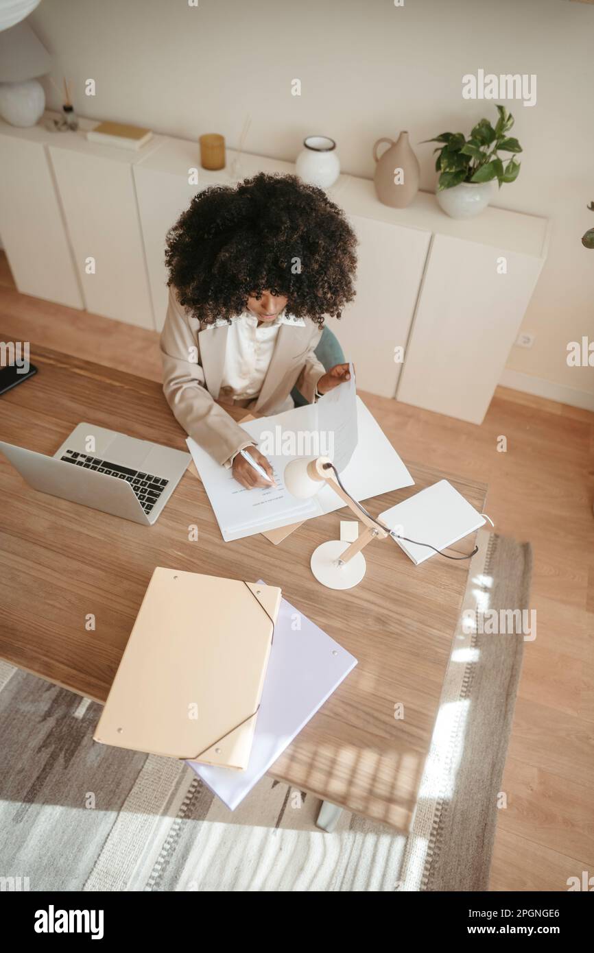 Businesswoman taking notes working in office Stock Photo