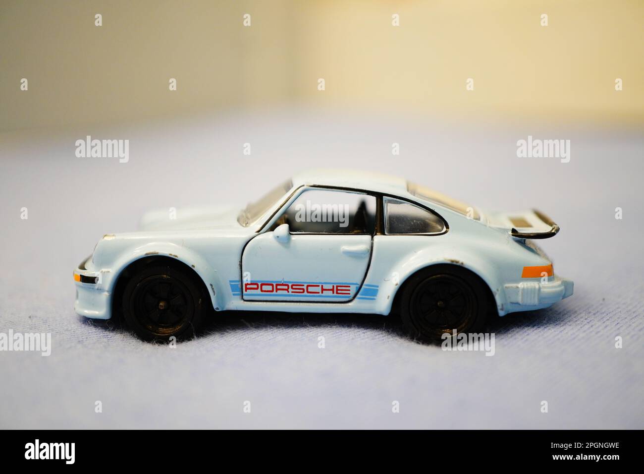 A toy Porsche car resting on a blue bedsheet Stock Photo - Alamy