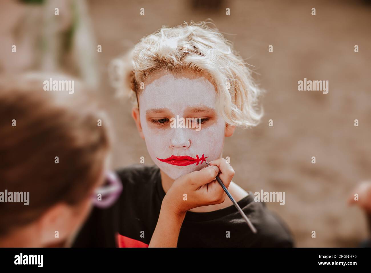 Boy having face painting from artist Stock Photo Alamy