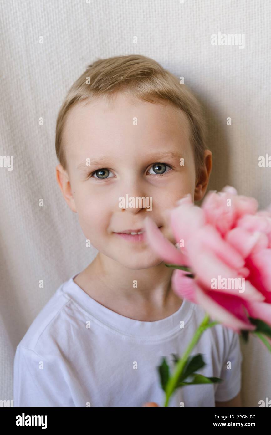Cute boy holding pink flower Stock Photo Alamy