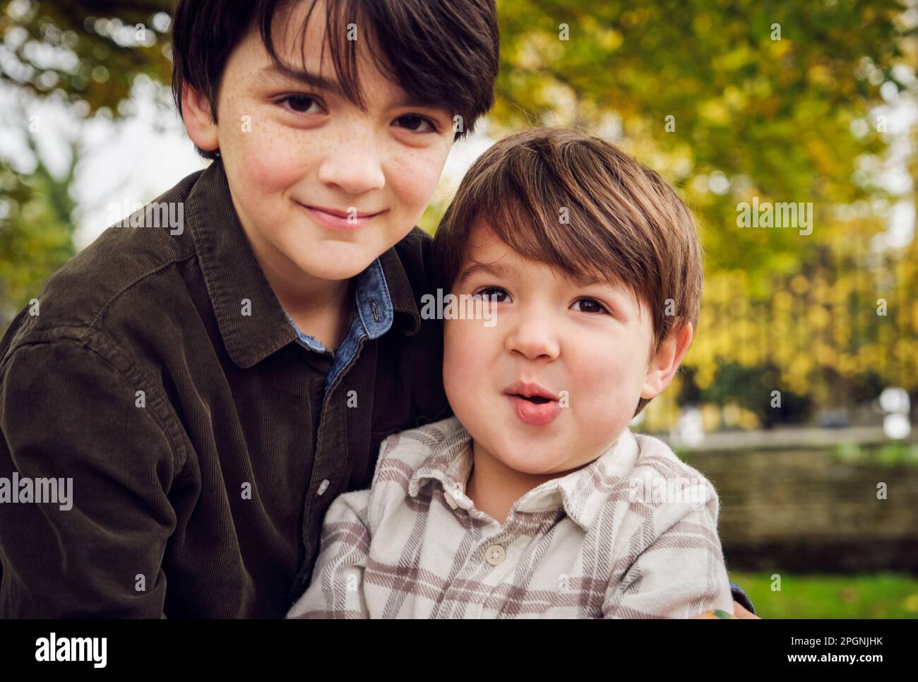 Cute brothers wearing casual clothing at park Stock Photo