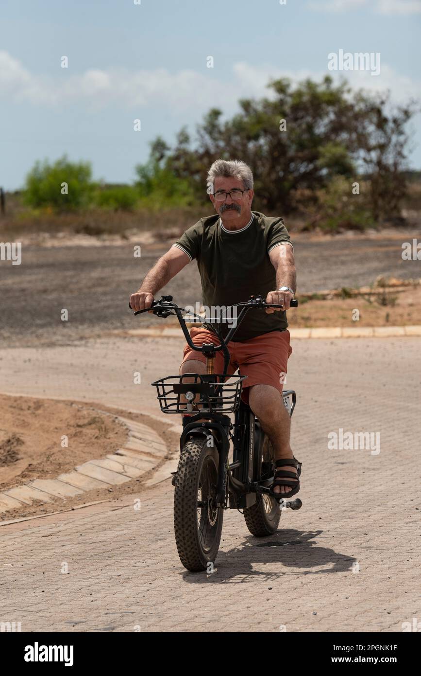 Western Cape, South Africa. 2023. Man riding an electric bike, taking a