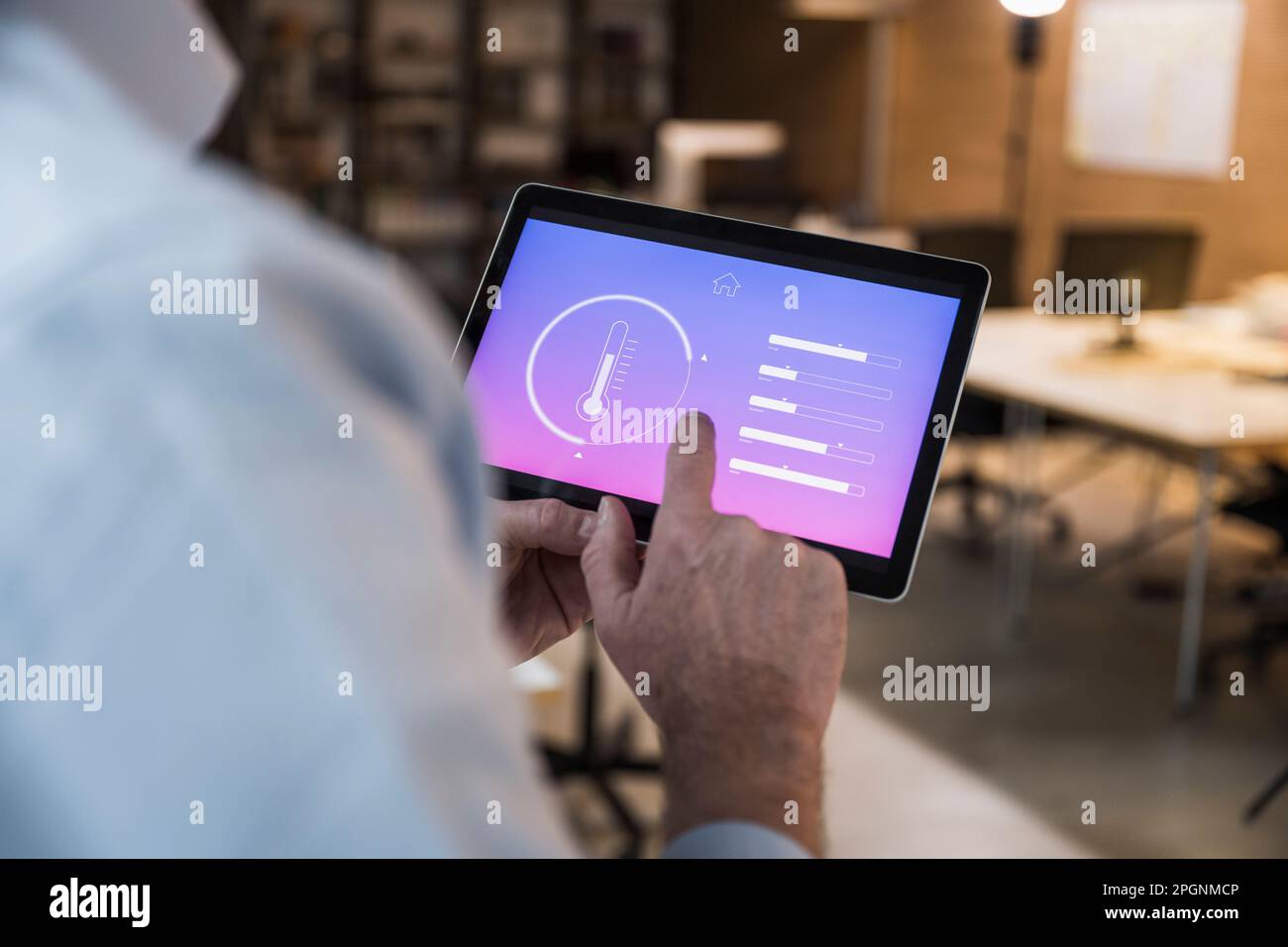 Businessman using automation app on tablet PC at office Stock Photo