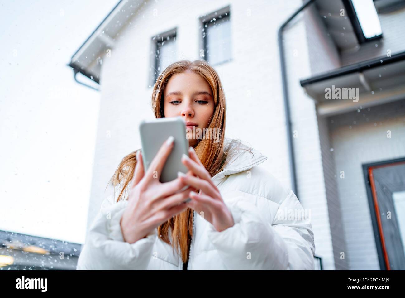 Teenage girl using smart phone outside home Stock Photo - Alamy