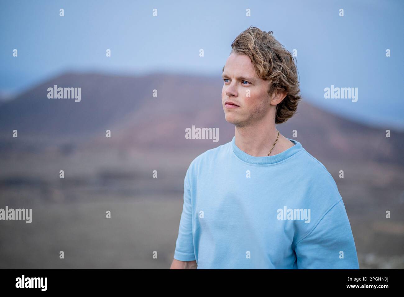 Contemplative young man wearing blue t-shirt Stock Photo