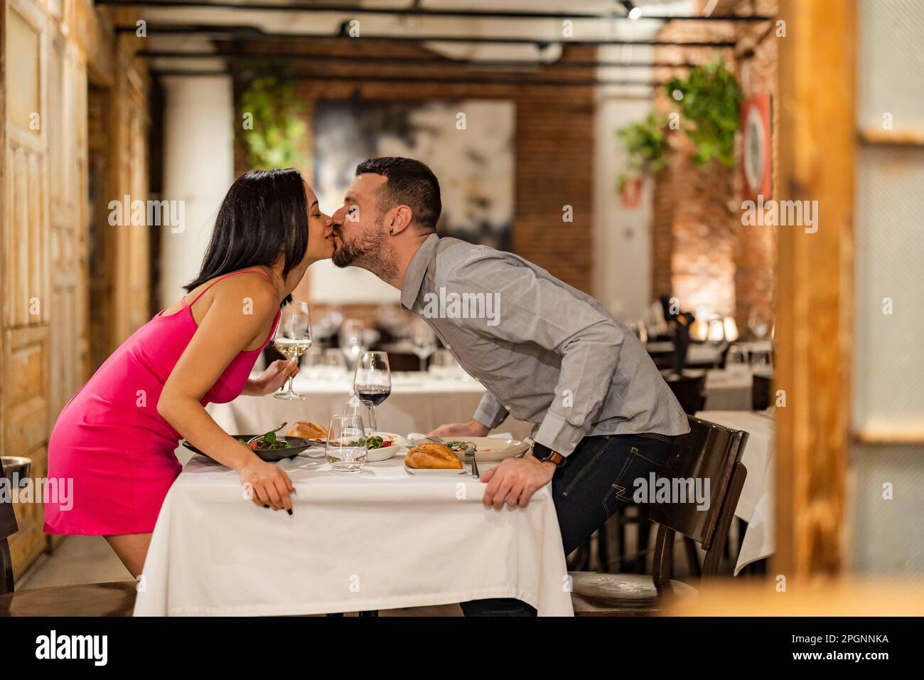 Romantic couple kissing at restaurant Stock Photo