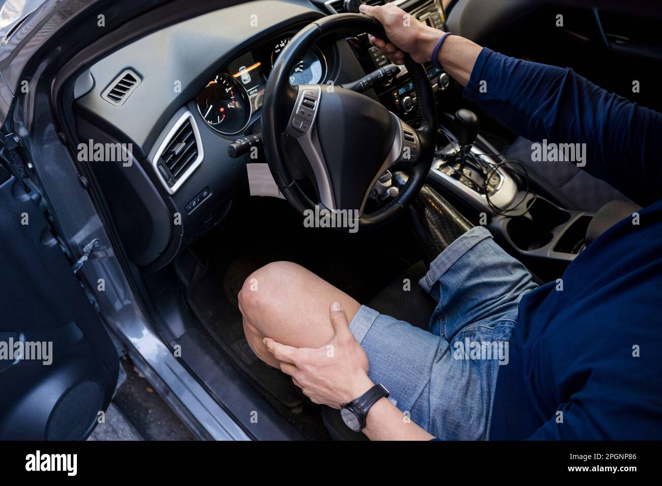 Man with disability holding steering wheel of car Stock Photo